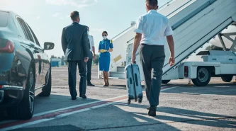 chauffeur-is-carrying-boss-luggage-while-walking-with-him-from-car-plane-pandemic