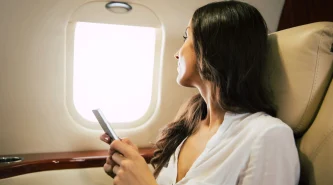close-up-photo-charming-woman-flying-business-class-who-is-smiling-looking-camera-while-talking-phone
