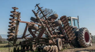 low-angle-view-abandoned-machinery-field-against-sky
